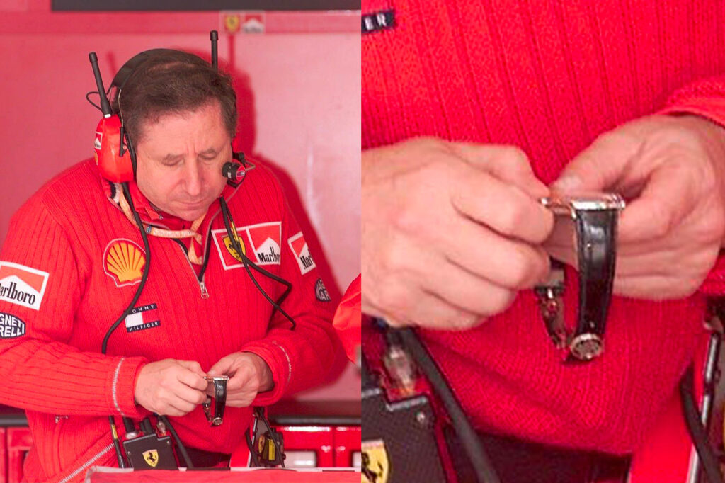 Jean Todt in the red Ferrari suit while he is concentrated on winding his Patek Philippe watch in his hands
